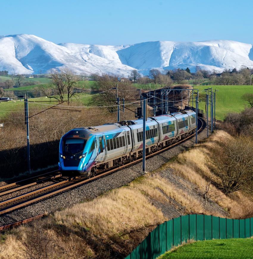 Train with snowy mountains in background, scenic railway journey