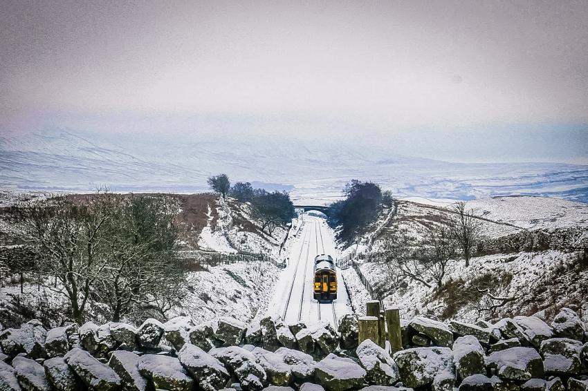 Train in the distance with rolling snowy countryside