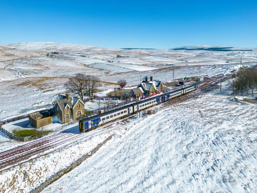 Ribblehead Station with snow covered mountains in the background