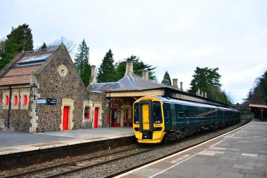 Train at station with stone brick station building in background