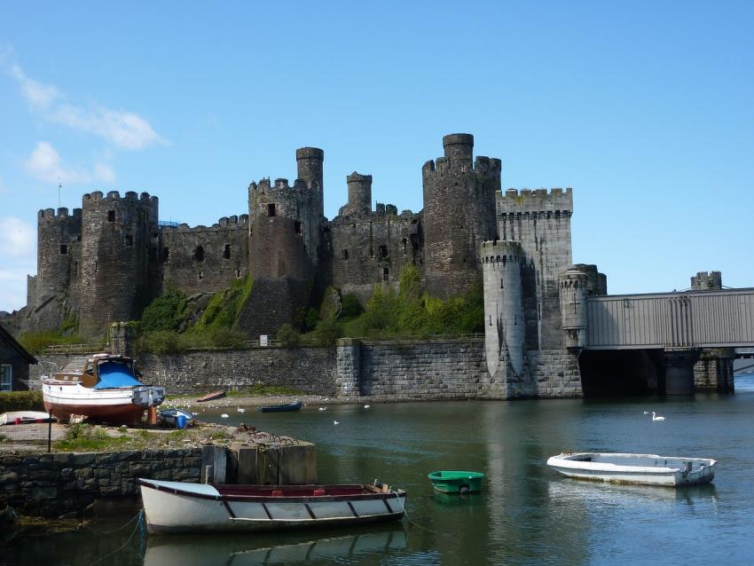 Stunning castle with boats in a body of water in the foreground