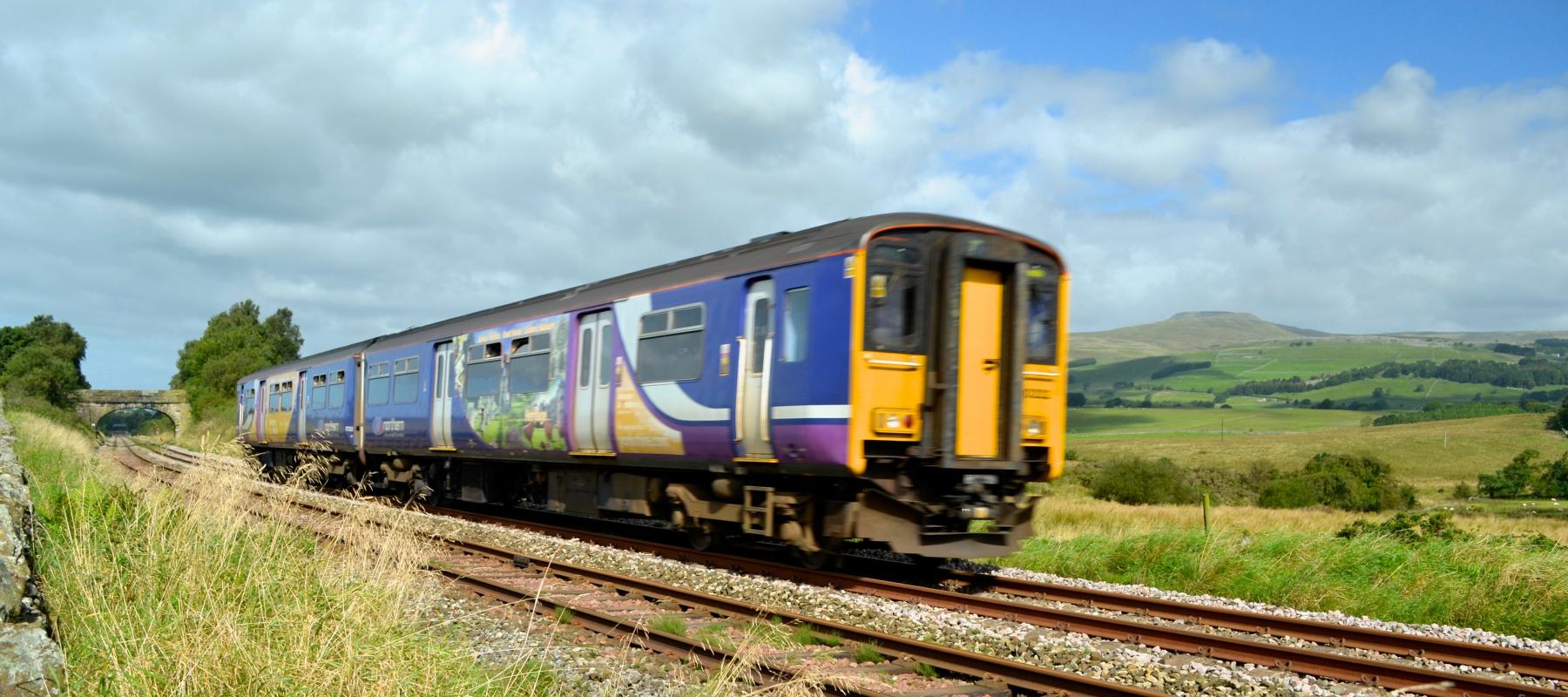 Train passing Ingleborough, near Clapham along the Bentham Line. Yorkshire & North East UK